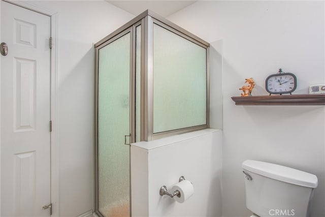 bathroom with toilet and a shower with shower door