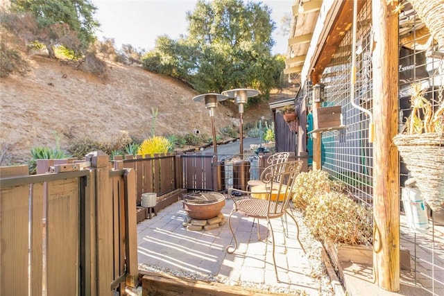 view of patio / terrace featuring fence and a fire pit