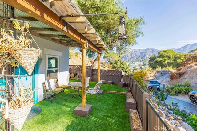 view of yard with a fenced backyard and a mountain view