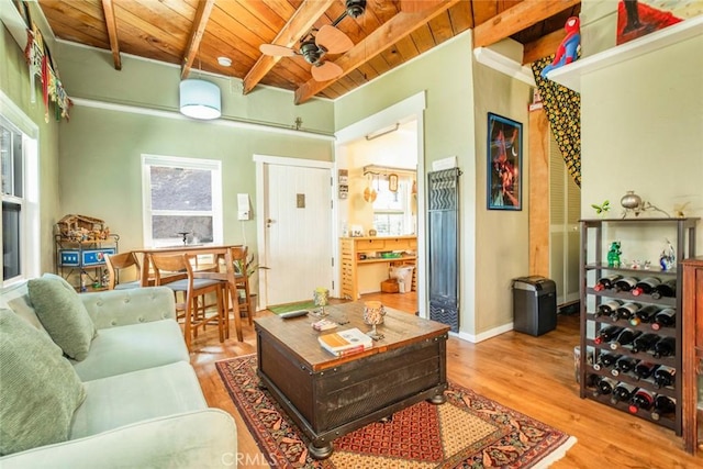 living area featuring a wealth of natural light, wooden ceiling, beam ceiling, and wood finished floors