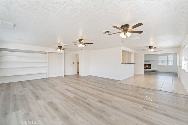 unfurnished living room featuring light wood-type flooring and ceiling fan