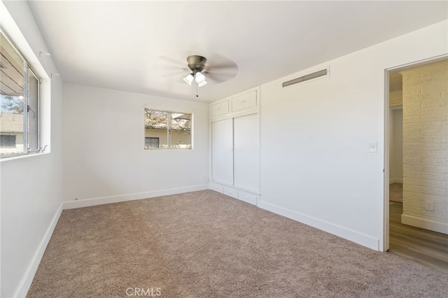 unfurnished bedroom featuring carpet flooring, multiple windows, a closet, and ceiling fan