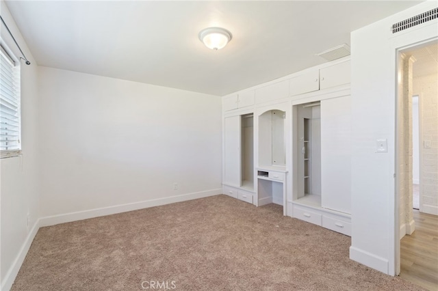 unfurnished bedroom featuring a closet and light colored carpet