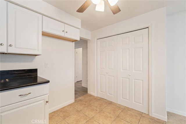 kitchen featuring white cabinetry, ceiling fan, and light tile patterned floors