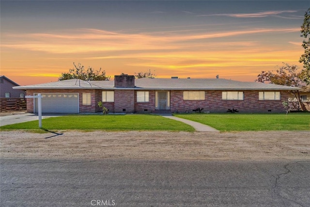 single story home featuring a lawn and a garage