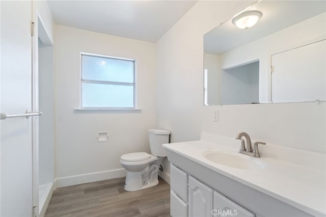 bathroom featuring vanity, wood-type flooring, and toilet