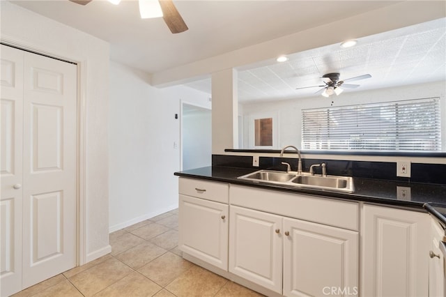 kitchen with decorative backsplash, ceiling fan, light tile patterned floors, white cabinetry, and sink