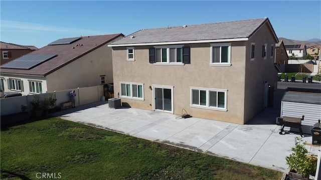 back of property with central AC, a yard, and a patio