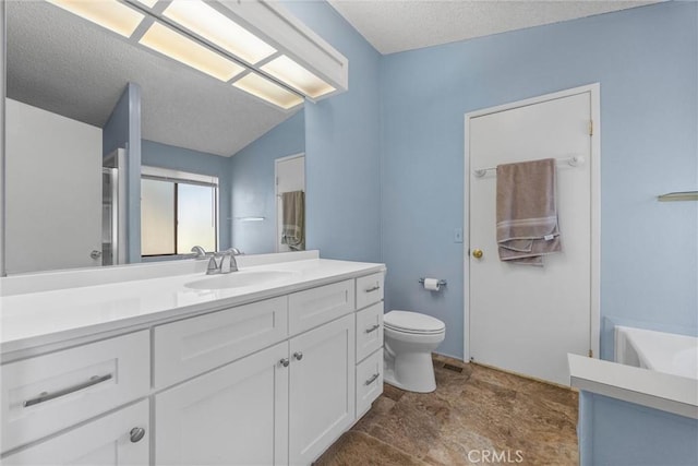 bathroom featuring toilet, lofted ceiling, a textured ceiling, and vanity