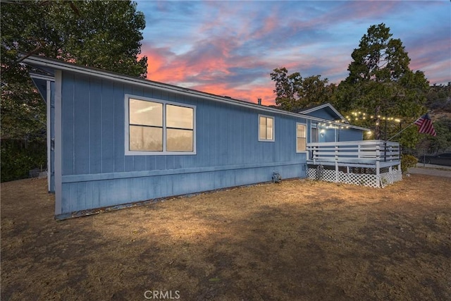 property exterior at dusk with a wooden deck