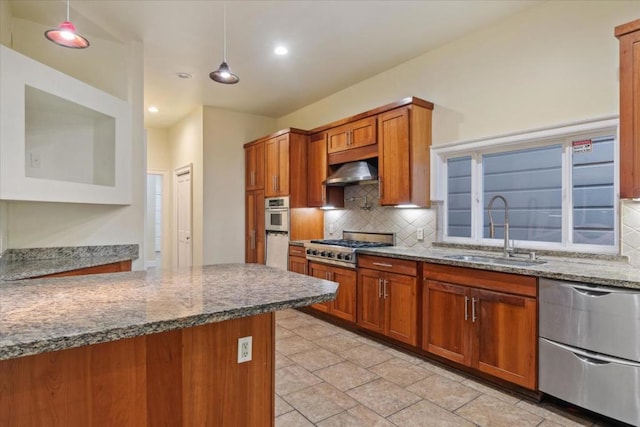 kitchen featuring pendant lighting, backsplash, light stone counters, and sink