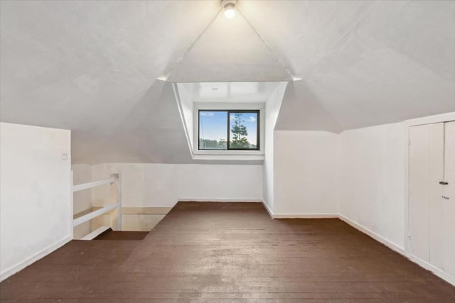 bonus room featuring vaulted ceiling and dark wood-type flooring