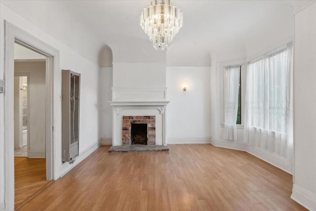 unfurnished living room featuring plenty of natural light, light hardwood / wood-style flooring, and a fireplace