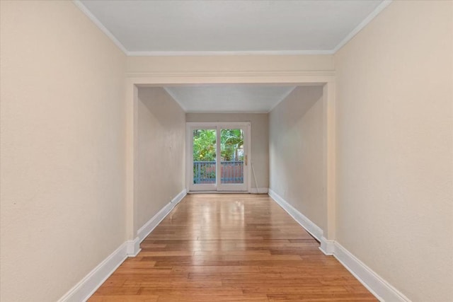 hall with crown molding and light hardwood / wood-style flooring