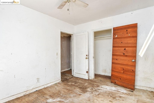 unfurnished bedroom featuring wood-type flooring, a closet, and ceiling fan