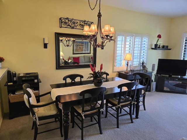 dining room with carpet flooring and an inviting chandelier