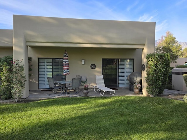 rear view of property featuring a patio and a lawn