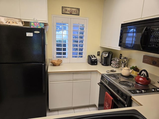 kitchen with black appliances, light tile patterned flooring, and white cabinetry