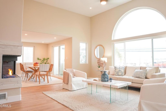 living room featuring a towering ceiling and light wood-type flooring