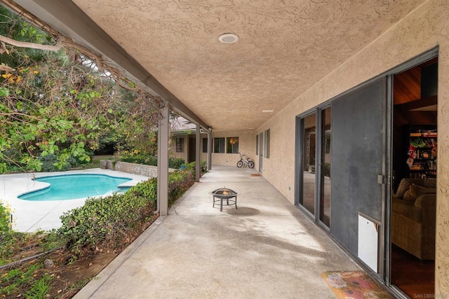 view of swimming pool featuring a fire pit and a patio area