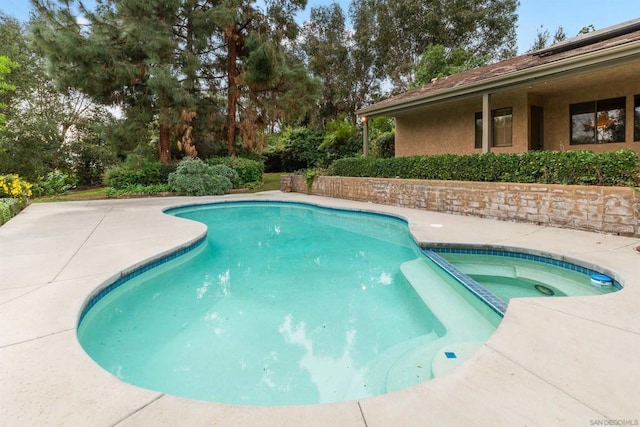 view of pool featuring a patio area and an in ground hot tub