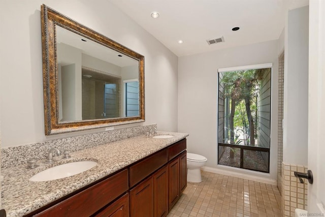 bathroom with tile patterned flooring, vanity, and toilet