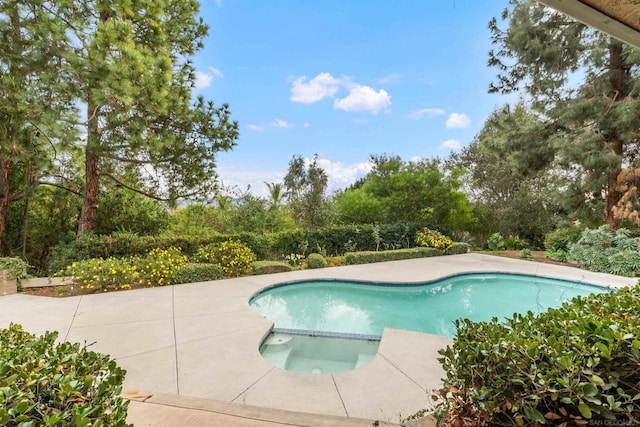 view of swimming pool featuring a patio area and an in ground hot tub