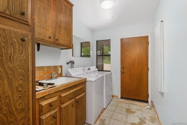 laundry room with cabinets, separate washer and dryer, and sink