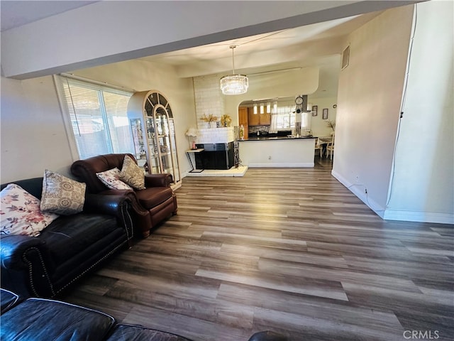 living room with hardwood / wood-style floors, a chandelier, and a large fireplace