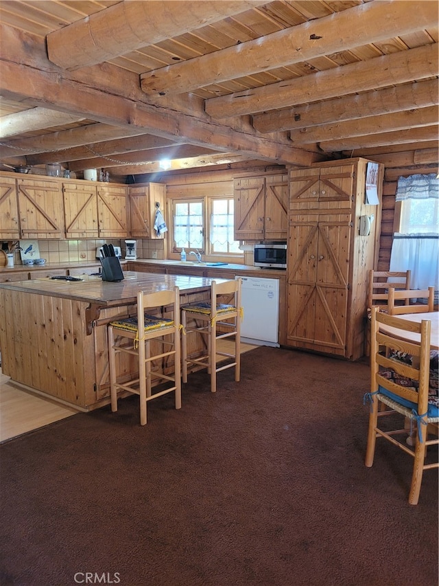 kitchen with beamed ceiling, dishwasher, dark colored carpet, and wooden ceiling