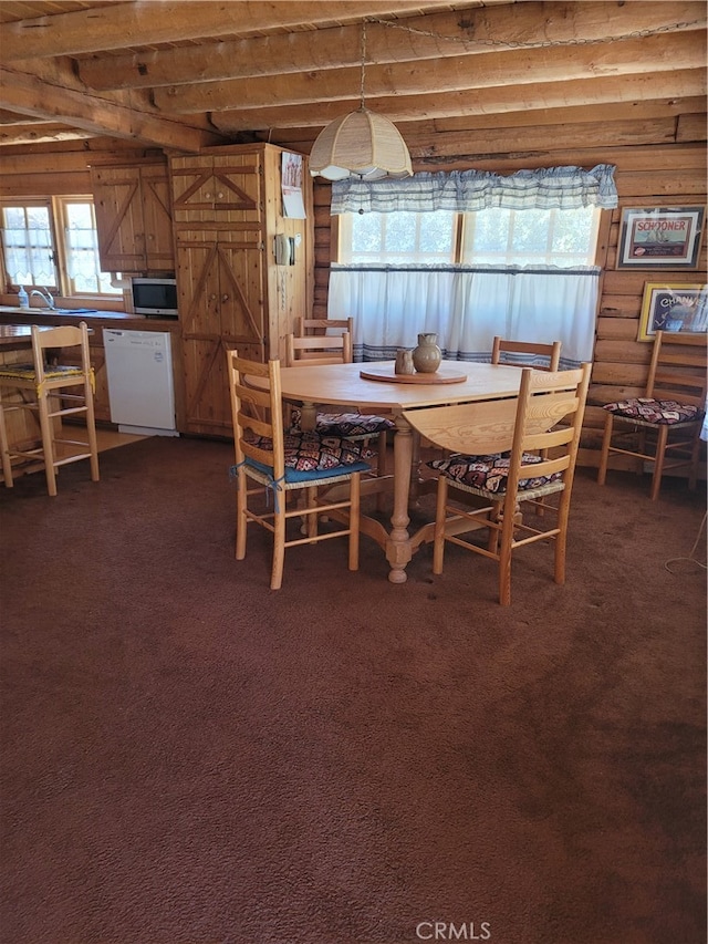 carpeted dining room featuring beamed ceiling