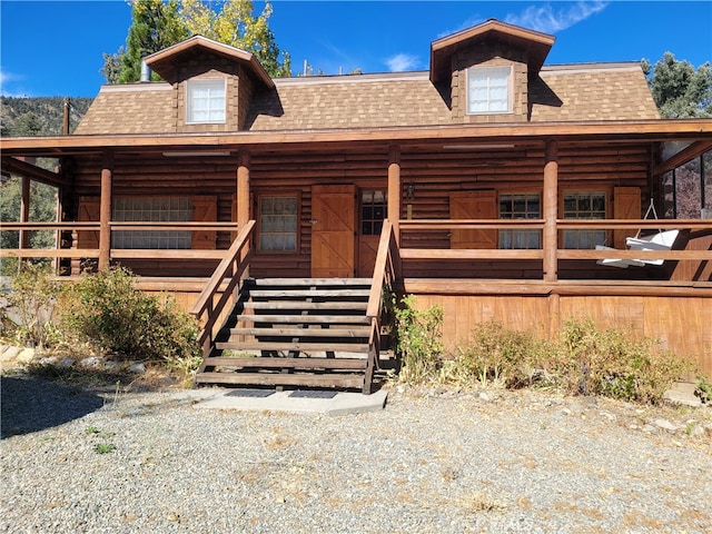 log cabin featuring covered porch