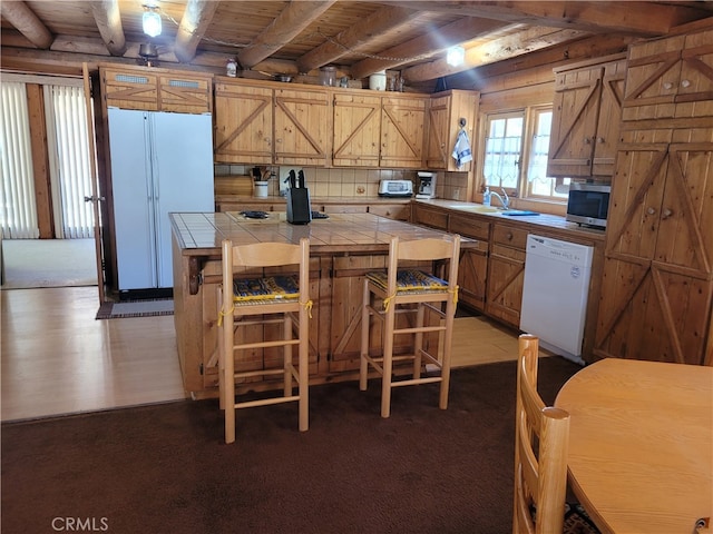 kitchen with backsplash, dark hardwood / wood-style flooring, dishwasher, tile counters, and sink