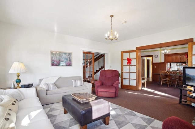 carpeted living room with a chandelier