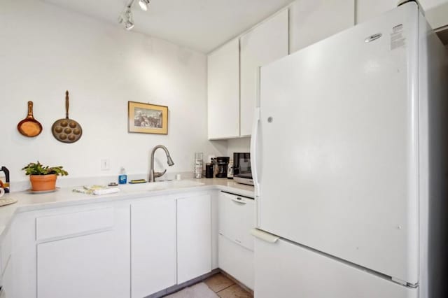 kitchen with white cabinetry, white fridge, and light tile patterned floors