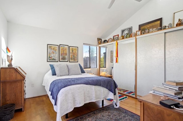 bedroom with hardwood / wood-style flooring, ceiling fan, vaulted ceiling, and a closet