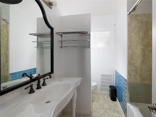 full bathroom with tile patterned flooring, toilet, tile walls, and sink