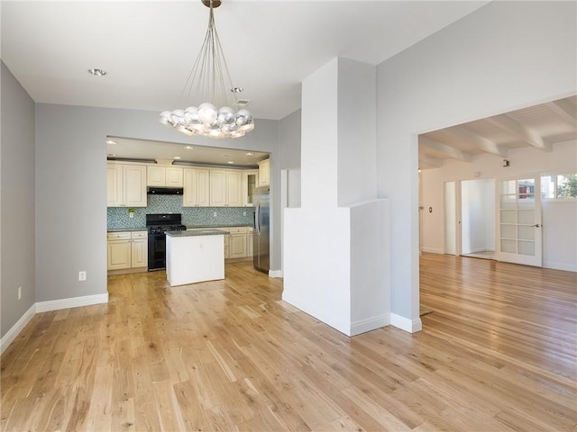 kitchen with black gas range, stainless steel refrigerator, light hardwood / wood-style flooring, and backsplash