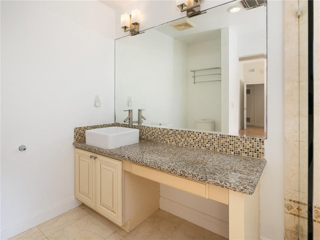 bathroom with vanity, toilet, and backsplash