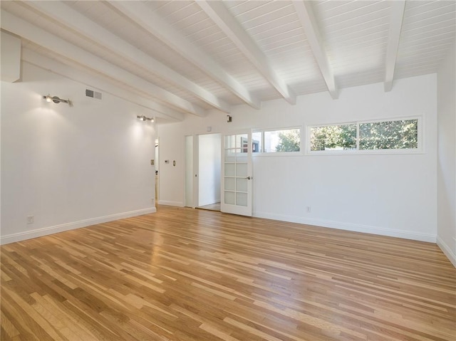 unfurnished room featuring beamed ceiling and light hardwood / wood-style floors