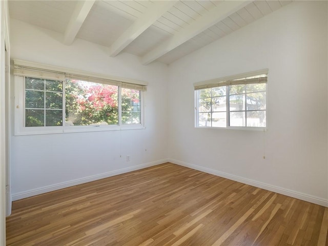 spare room featuring hardwood / wood-style floors and vaulted ceiling with beams