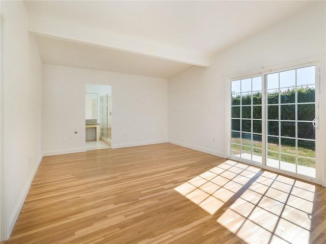 unfurnished room featuring lofted ceiling with beams and light hardwood / wood-style floors