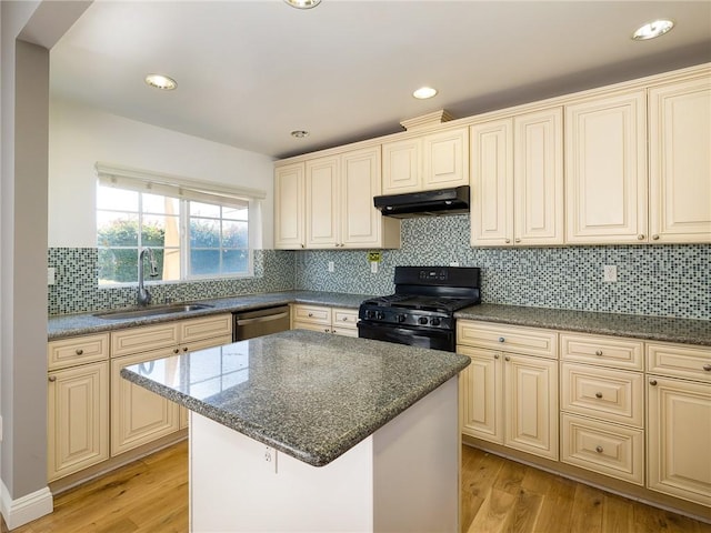 kitchen featuring black gas range, sink, a kitchen island, and light hardwood / wood-style floors