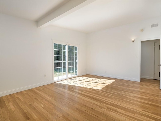 unfurnished room featuring beam ceiling and light hardwood / wood-style flooring