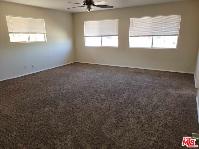 carpeted spare room with ceiling fan