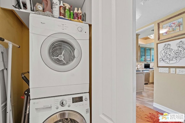 laundry area with stacked washer and dryer and light tile patterned floors