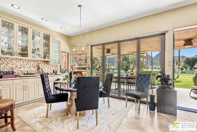 dining space featuring a chandelier, indoor bar, and light tile patterned floors