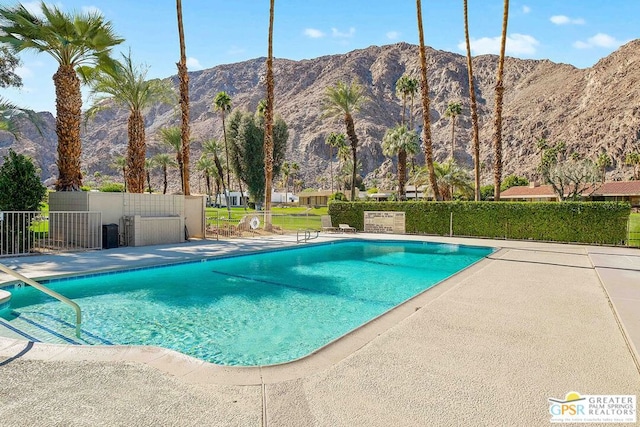 view of pool with a patio and a mountain view