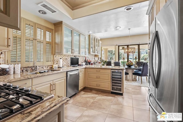 kitchen with stainless steel appliances, sink, decorative light fixtures, beverage cooler, and tasteful backsplash