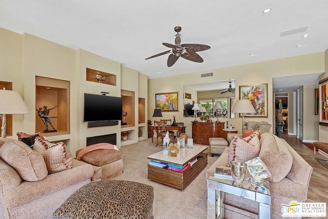 carpeted living room with ceiling fan